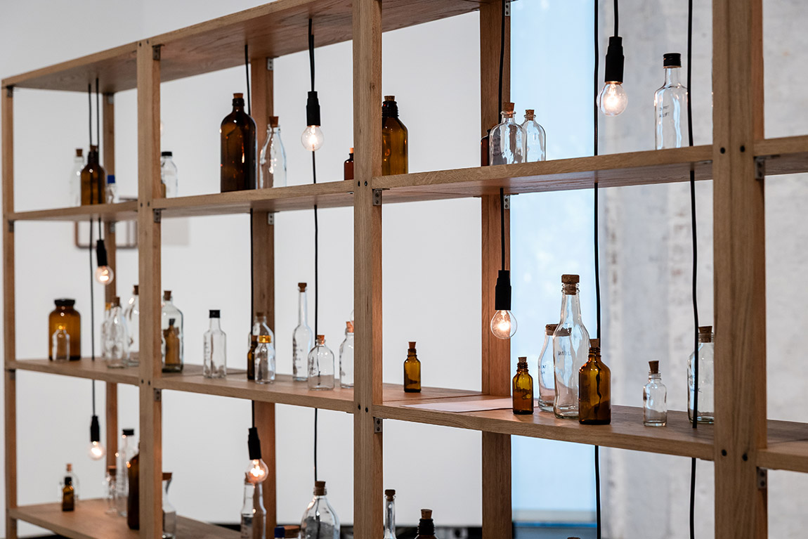 Untitled (Spoken Poem in a Bottle) 2018–ongoing wood, glass bottles, light bulbs 174 x 331.5 x 30.5 cm | Possehl Prize for International Art 2025 Shilpa Gupta in Lübeck: art across borders