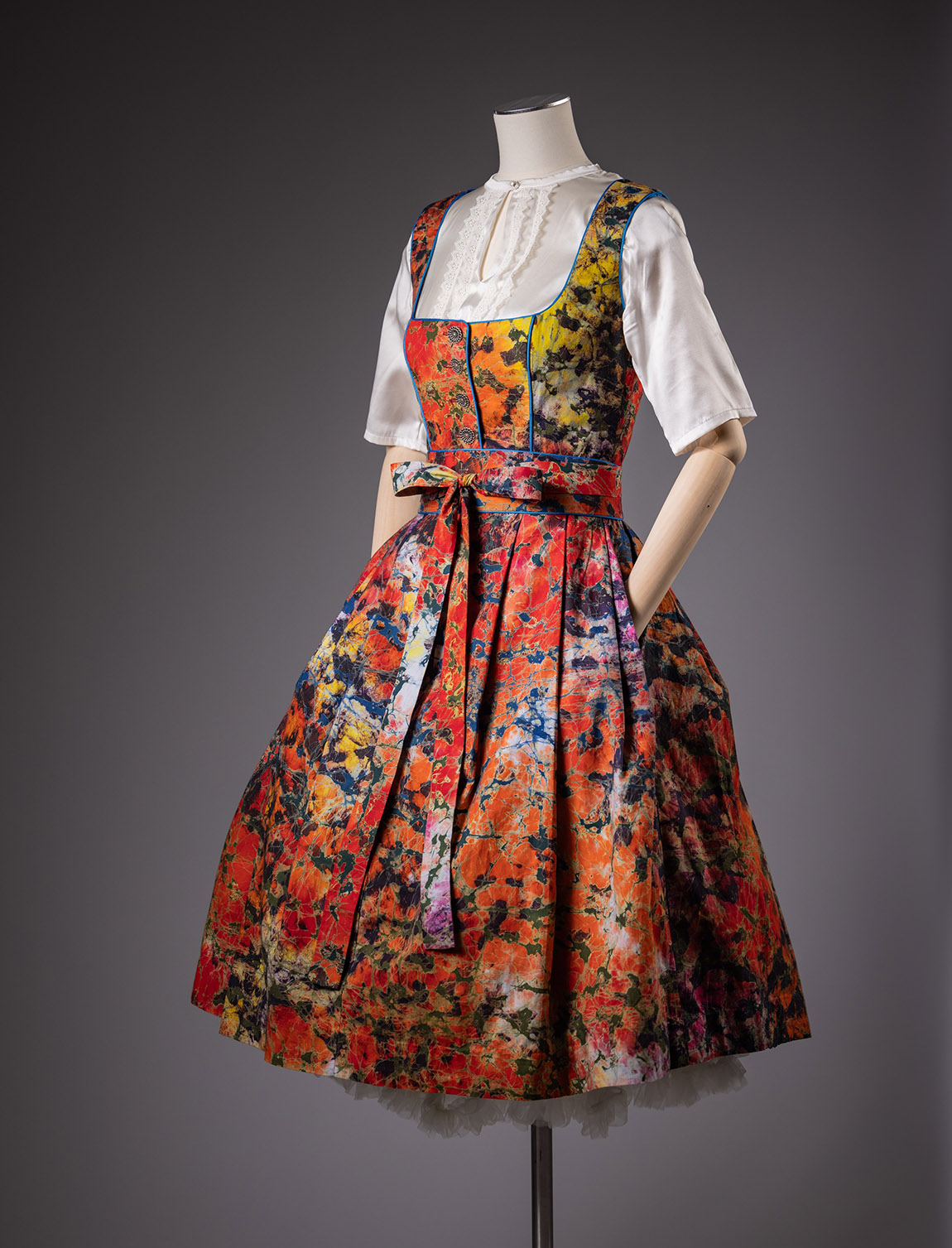 Modell ‚Dirndl à l´Africaine‘, Design Noh Nee, 2024 Das in Benin gefertigte Baumwolldirndl besteht aus einem farbintensiven Batikgewebe aus Ghana. Das Münchner Label ‚Noh Nee‘ setzt bewusst auf eine Zusammenarbeit mit lokalen Produzenten in Afrika. Foto: Christoph Jorda | Das Staatliche Textil- und Industriemuseum Augsburg (tim): ‚TRADITION GOES FASHION‘