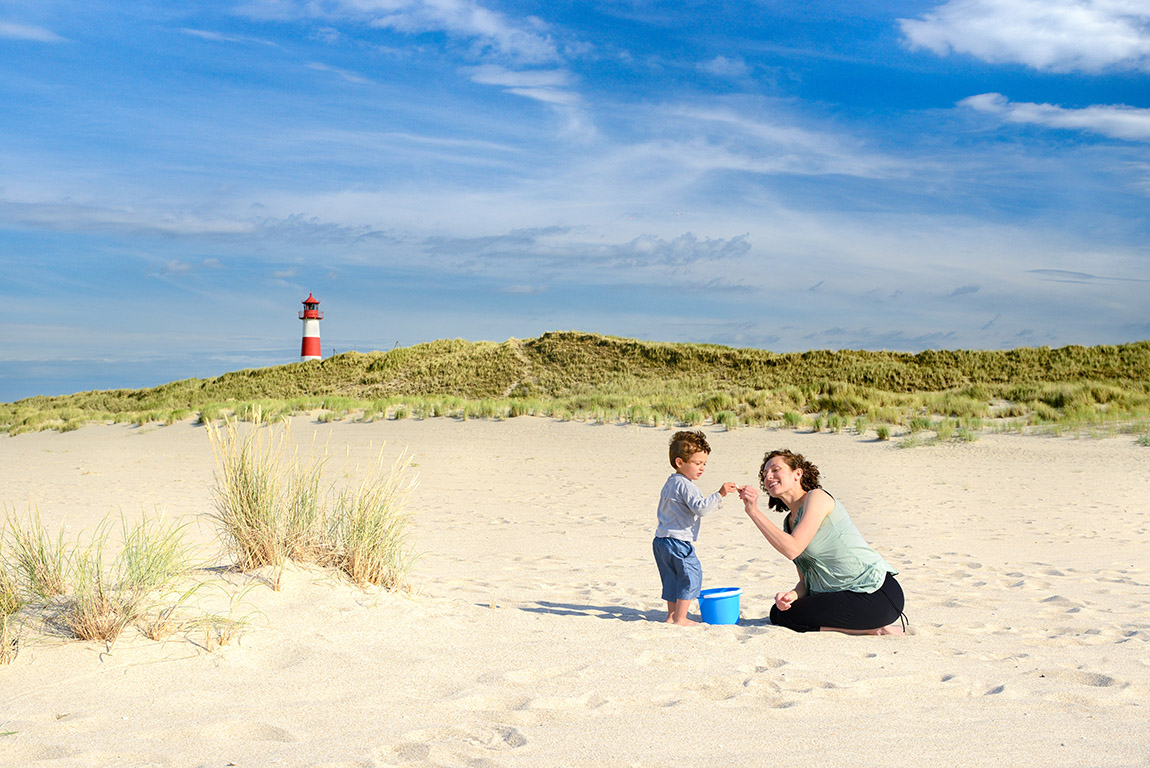 Ellenbogen Nature Sanctuary, Sylt. Photo: © DZT e.V., Francesco Carovillano | Sylt, Schleswig-Holstein, Germany - Mother and son playing on Ellenbogen beach with Leuchtturm List Ost in the background. --- With Model Release --- | Time to cool off – the top 12 swimming spots in Germany, Switzerland and Austria