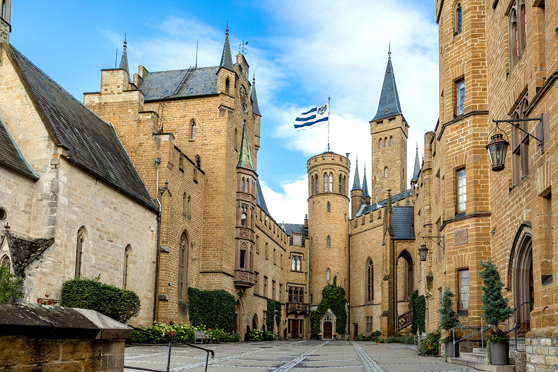 Dreh- und Angelpunkt Burghof. Hier finden die Besucher die Zugänge zu den Museumsräumen, zu den beiden Burg-Kapellen, zu den Kellergewölben, zum Restaurant, zum Biergarten zum Burg-Shop und zur Besucherinformation. | Hohenzollern Castle – history with a majestic view